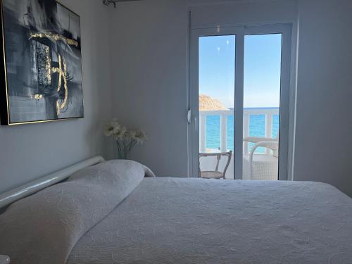 a bedroom with a bed and a view of the ocean at VILLA BLANCA in Haraki