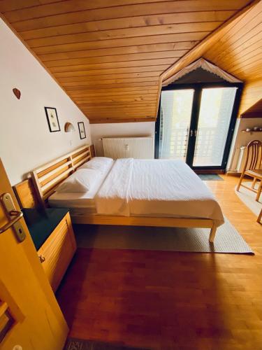a large bed in a room with a wooden ceiling at Apartma Snežinka in Kranjska Gora