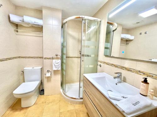 Un baño con inodoro, lavabo y ducha. en Casa Elizabeth, en Altea