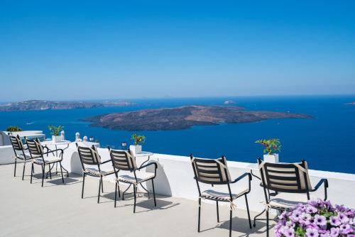 a row of chairs sitting on top of a roof at Lithies Traditional Homes in Firostefani