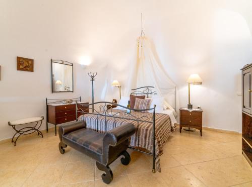 a bedroom with a bed and a chair at Lithies Traditional Homes in Firostefani
