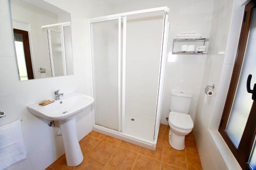 a white bathroom with a toilet and a sink at Senia Tomaset II in Onil