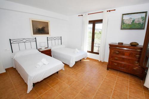 a bedroom with two beds and a dresser and a window at Senia Tomaset II in Onil
