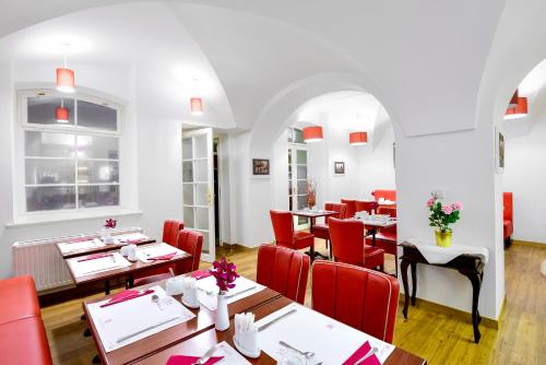 un ristorante con tavoli in legno e sedie rosse di Hotel Residence Green Lobster a Praga