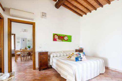 a bedroom with a bed and a dining room at Agriturismo Fontetrilla in Orbetello