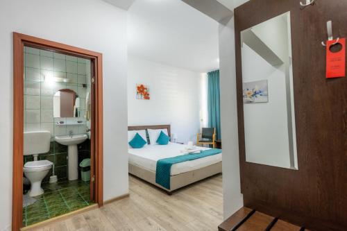 1 dormitorio con 1 cama y baño con lavamanos en Hotel Sir Lujerului en Bucarest