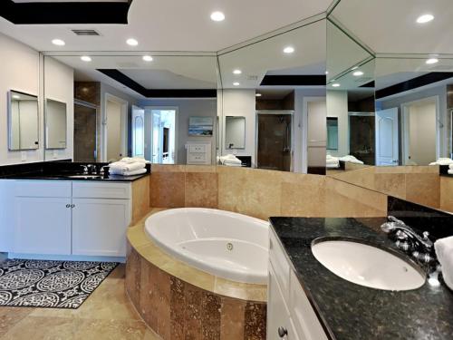 a large bathroom with a tub and a large mirror at Indigo West #2004 in Perdido Key