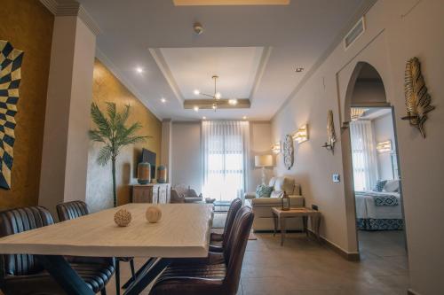 a dining room and living room with a table and chairs at Apartamentos Turísticos La Baílla in Rota