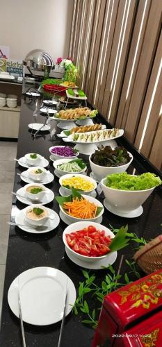 a buffet with many bowls of food on a table at CHRISTEE SUITES HOTEL in Melaka