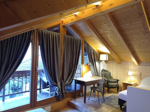 a room with a bed and a desk and a window at Telemark Mountain Rooms in Agordo