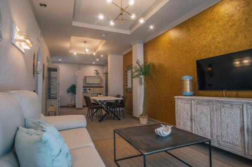 a living room with a couch and a flat screen tv at Apartamentos Turísticos La Baílla in Rota