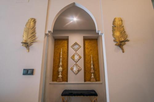 a hallway with an archway with feathers on the wall at Apartamentos Turísticos La Baílla in Rota