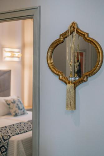 a mirror hanging on a wall next to a bed at Apartamentos Turísticos La Baílla in Rota