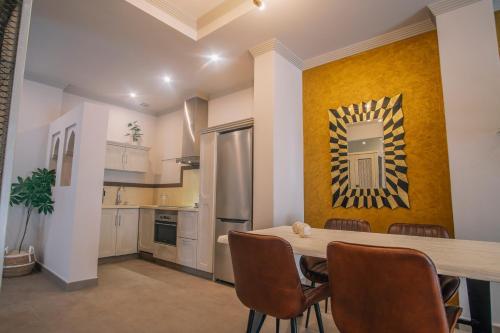 a kitchen with a table and chairs in a room at Apartamentos Turísticos La Baílla in Rota