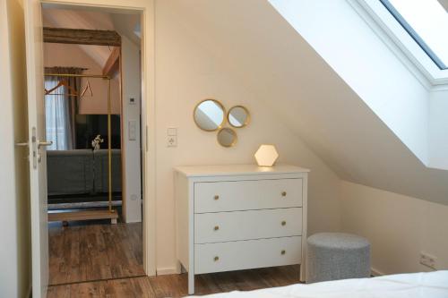 a bedroom with a white dresser and two mirrors at Modernes Loft in Ramstein - mit Sauna & TLA in Ramstein-Miesenbach