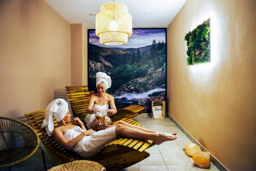 a man and woman sitting on a bench in a room at Bylo Nebylo apartmány in Vítkovice