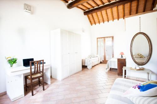 a living room with a bed and a desk and a mirror at Agriturismo Fontetrilla in Orbetello