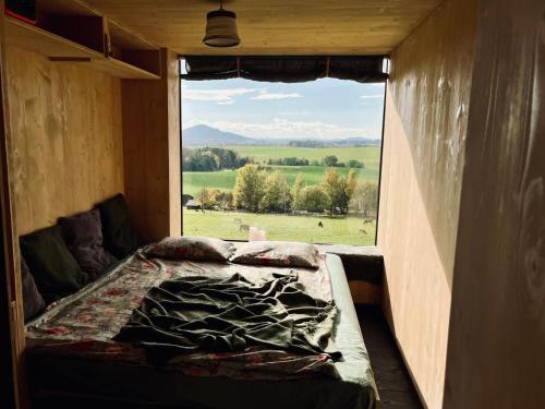 Bett in einem Zimmer mit einem großen Fenster in der Unterkunft Krabička K74 in Jablonné v Podještědí