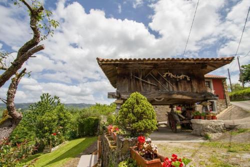 Casa Rural La Cuesta في Villarmil: منزل بسقف خشبي في حديقة