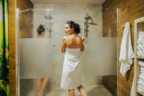 a woman in a white dress standing in a shower at Bylo Nebylo apartmány in Vítkovice