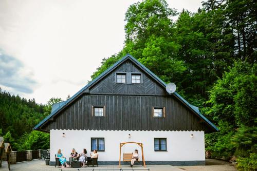 a group of people sitting at tables in front of a large building at Bylo Nebylo apartmány in Vítkovice