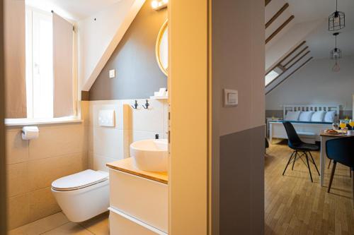 a bathroom with a sink and a toilet and a table at Paon Boutique Apartments in Zagreb