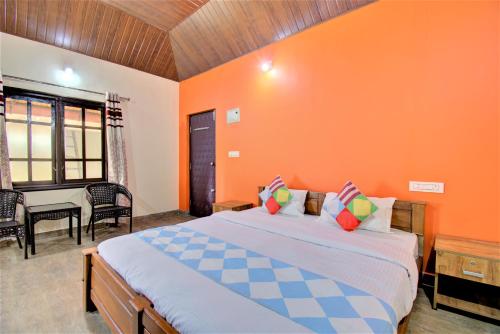 a bedroom with a large bed with an orange wall at Coorg Bliss Estate Stay in Madikeri