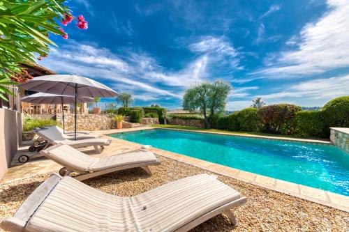 une piscine avec deux chaises longues et un parasol dans l'établissement Ma Maison à Valbonne - Villa Tainfony - 25min of MIPIM, à Valbonne