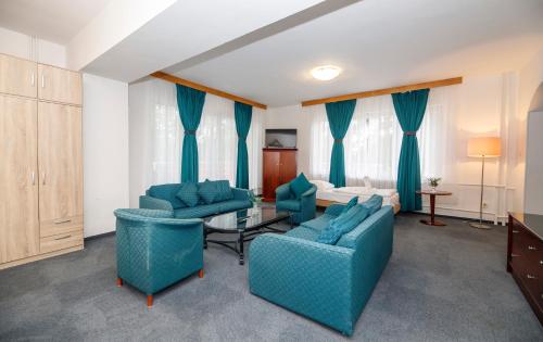 a living room with blue furniture and a bed at Fontána Lipno in Černá v Pošumaví