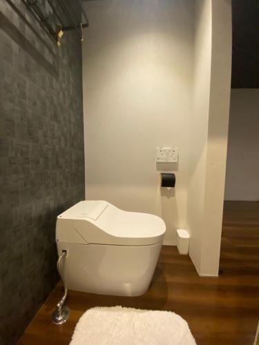 a bathroom with a white toilet in a room at Villa 33 Kashikojima in Ugata