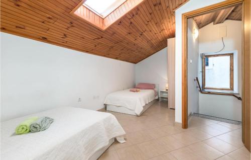 a bedroom with two beds and a skylight at 2 Bedroom Gorgeous Home In Susak in Susak