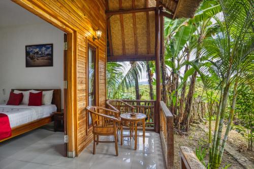 1 dormitorio con 1 cama, mesa y sillas en Indah Guest House Nusa Penida en Nusa Penida