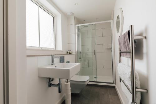 a white bathroom with a sink and a toilet at Charlecote House in Bath