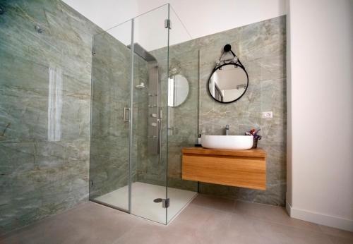 a bathroom with a sink and a glass shower at B&B Riccioli in Catania