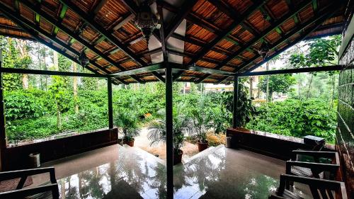 a screened in porch with a view of a garden at Coorg Bliss Estate Stay in Madikeri