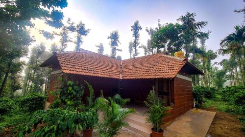 a small brick house in the middle of a forest at Coorg Bliss Estate Stay in Madikeri
