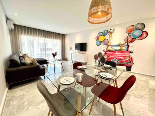 a living room with a glass table and a car on the wall at GAUTHIER Living By ShortStayCasa 1BED or 2BEDS - THE HEART OF TOWN in Casablanca