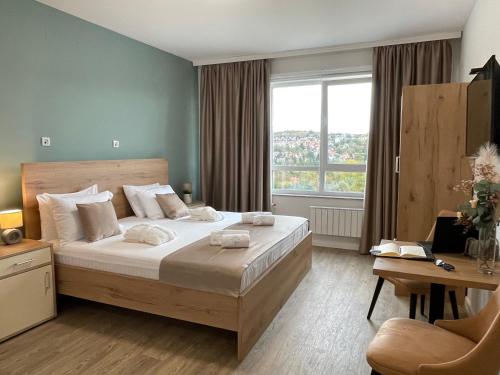 1 dormitorio con cama y ventana grande en Nordic Resort en Novi Sad