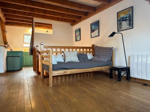 1 dormitorio con cama de madera y almohadas en Top floor duplex with private beach en Duingt