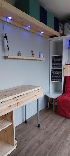 una camera con scrivania in legno e divano rosso di Studio fonctionnel 16m2 avec vue panoramique a Puy-Saint-Vincent