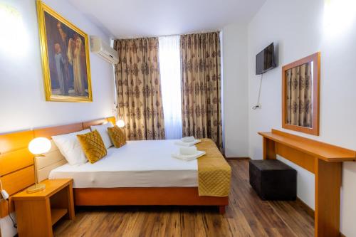 a hotel room with a bed and a window at Hotel Sir Lujerului in Bucharest