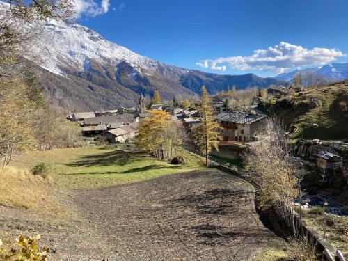 a village on a hill with a snow covered mountain at Appartamento Lou Touas dou Lamet a Moncenisio in Moncenisio