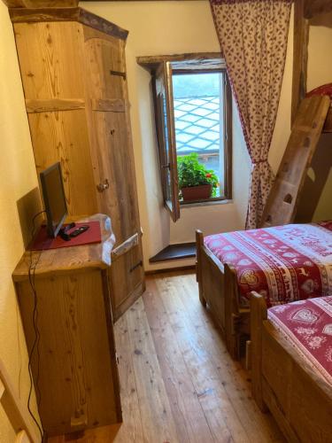a bedroom with a bed and a window at Appartamento Lou Touas dou Lamet a Moncenisio in Moncenisio