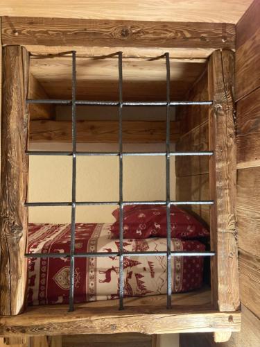 a wooden bunk bed with iron bars on it at Appartamento Lou Touas dou Lamet a Moncenisio in Moncenisio