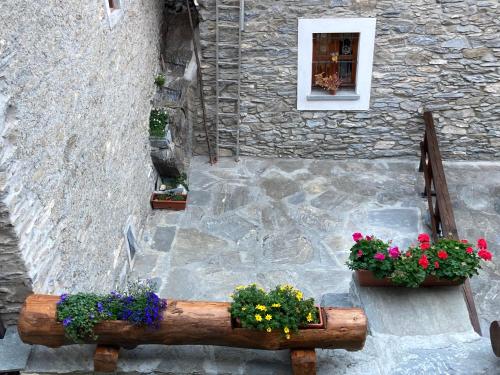a stone building with two flower boxes and a window at Appartamento Lou Touas dou Lamet a Moncenisio in Moncenisio