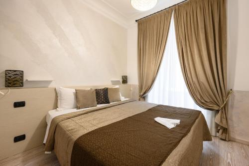 Cola Di Rienzo Suite Guest House في روما: غرفة نوم بسرير كبير ونافذة كبيرة