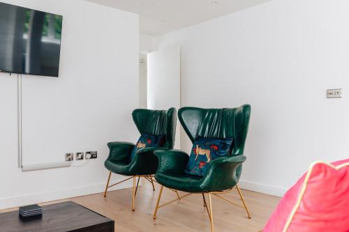 two green chairs sitting in a living room at Charlecote House in Bath