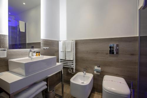 a bathroom with a sink and a toilet at Luxmarì Hotel & Spa in Castellammare del Golfo