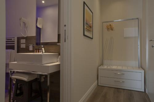 a bathroom with a sink and a mirror at Luxmarì Hotel & Spa in Castellammare del Golfo