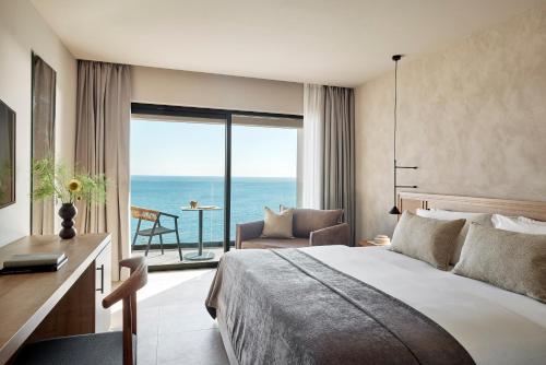 Helea Lifestyle Beach Resort في كاليثيا رودس: غرفة نوم مع سرير وإطلالة على المحيط